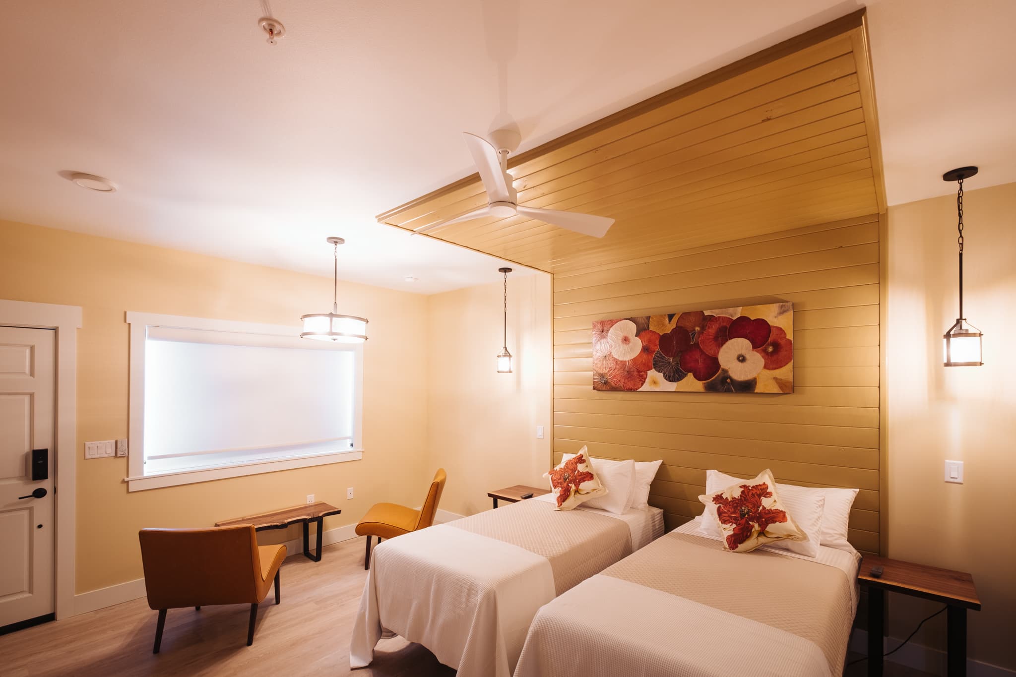 Interior view of the Tannin Suite showing beds, sitting area, entrance to bathroom. Warm colors