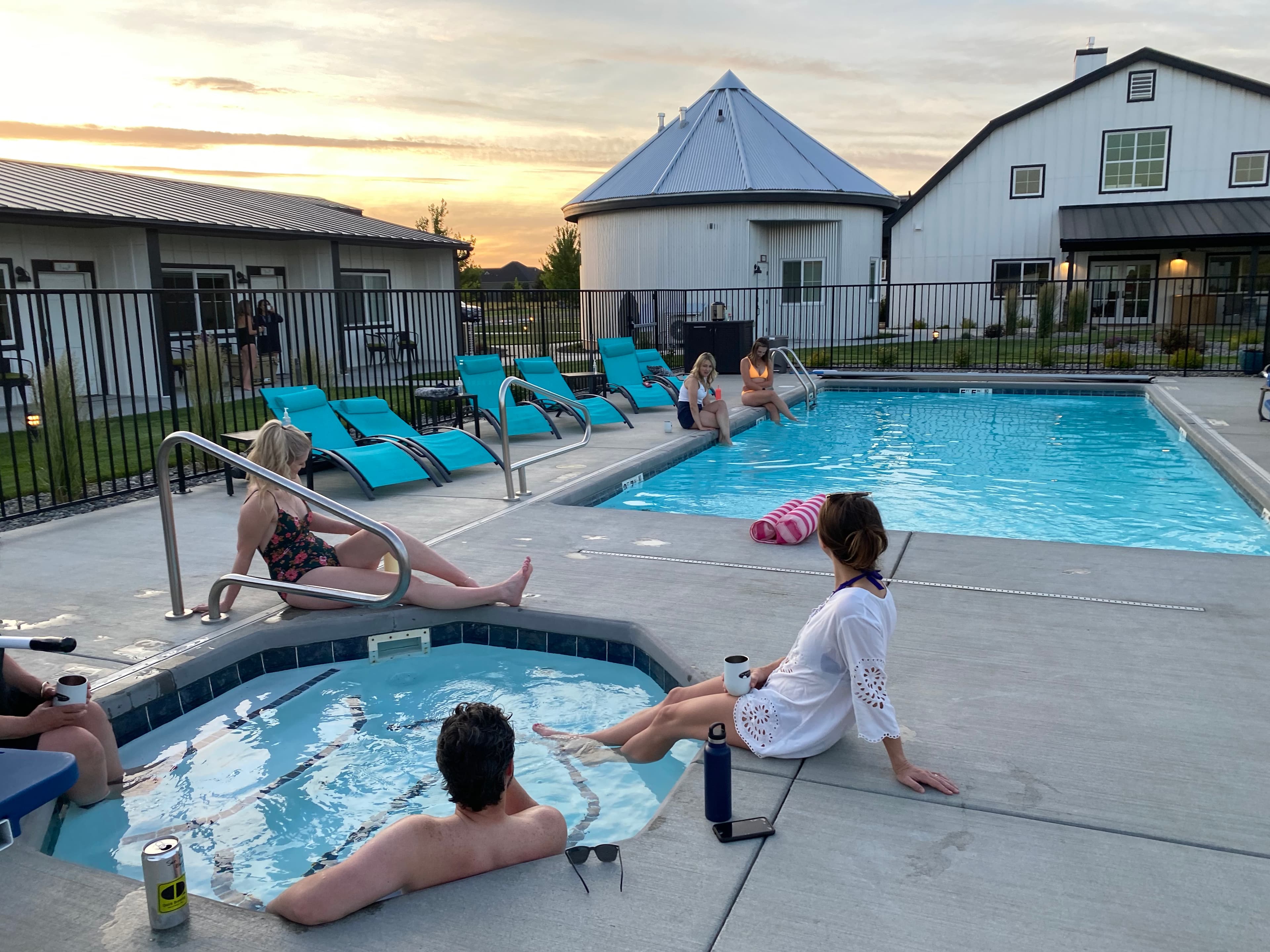 Guests enjoying the heated outdoor pool, hot tub. Also showing the silo suite and main barn building