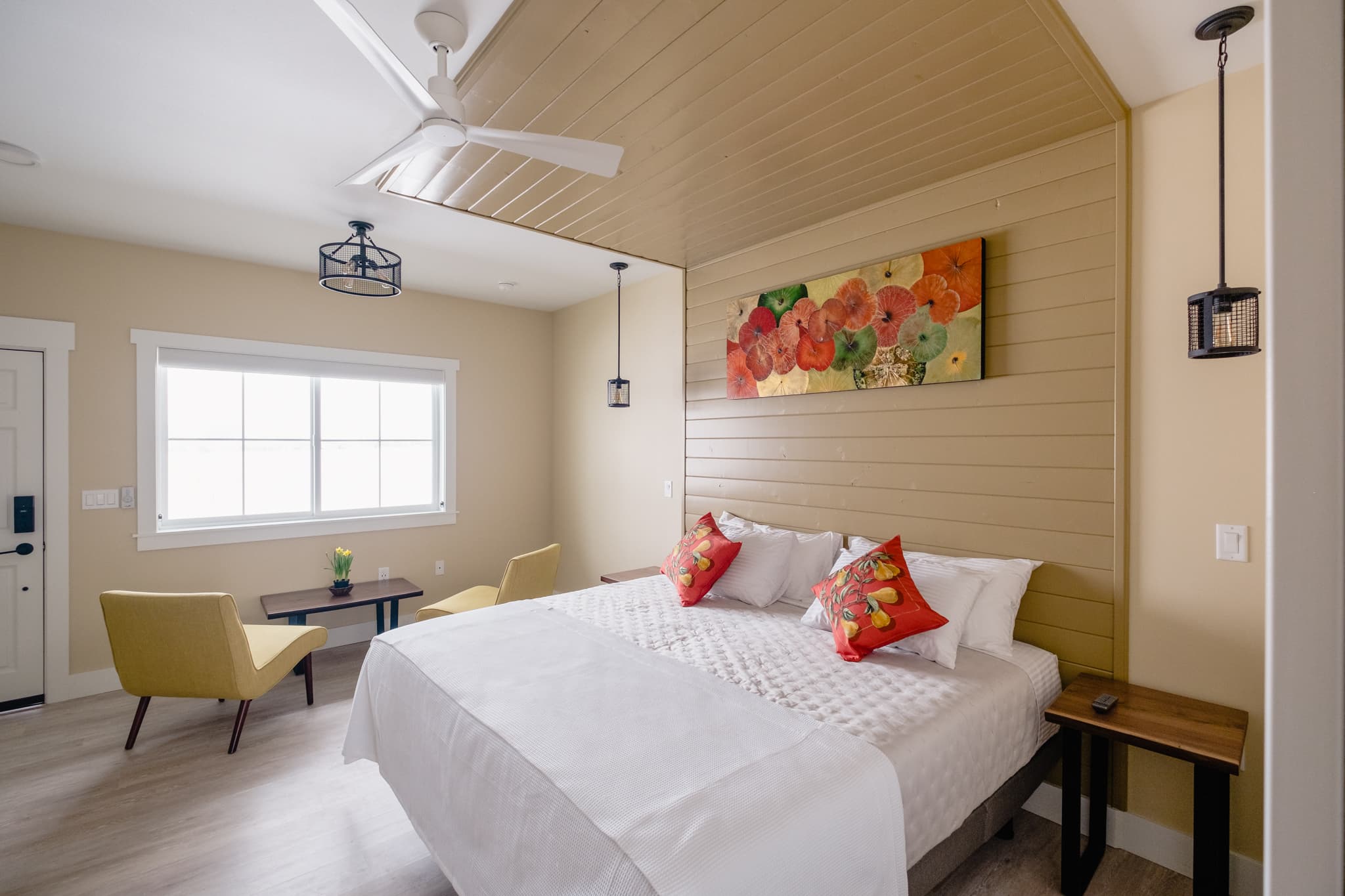Interior view of the Brix Suite showing beds, sitting area, entrance to bathroom. Warm colors