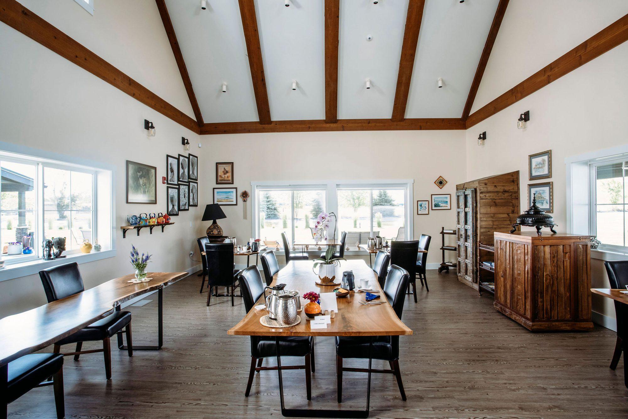 Julian's Hall at The Barn Walla Walla — a vaulted room with exposed beams and a long live-edge walnut table