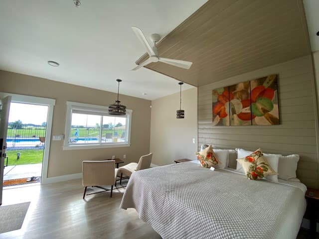 Interior view of the Loess Suite showing beds, sitting area, looking out to pool and Blue Mountains. Warm colors