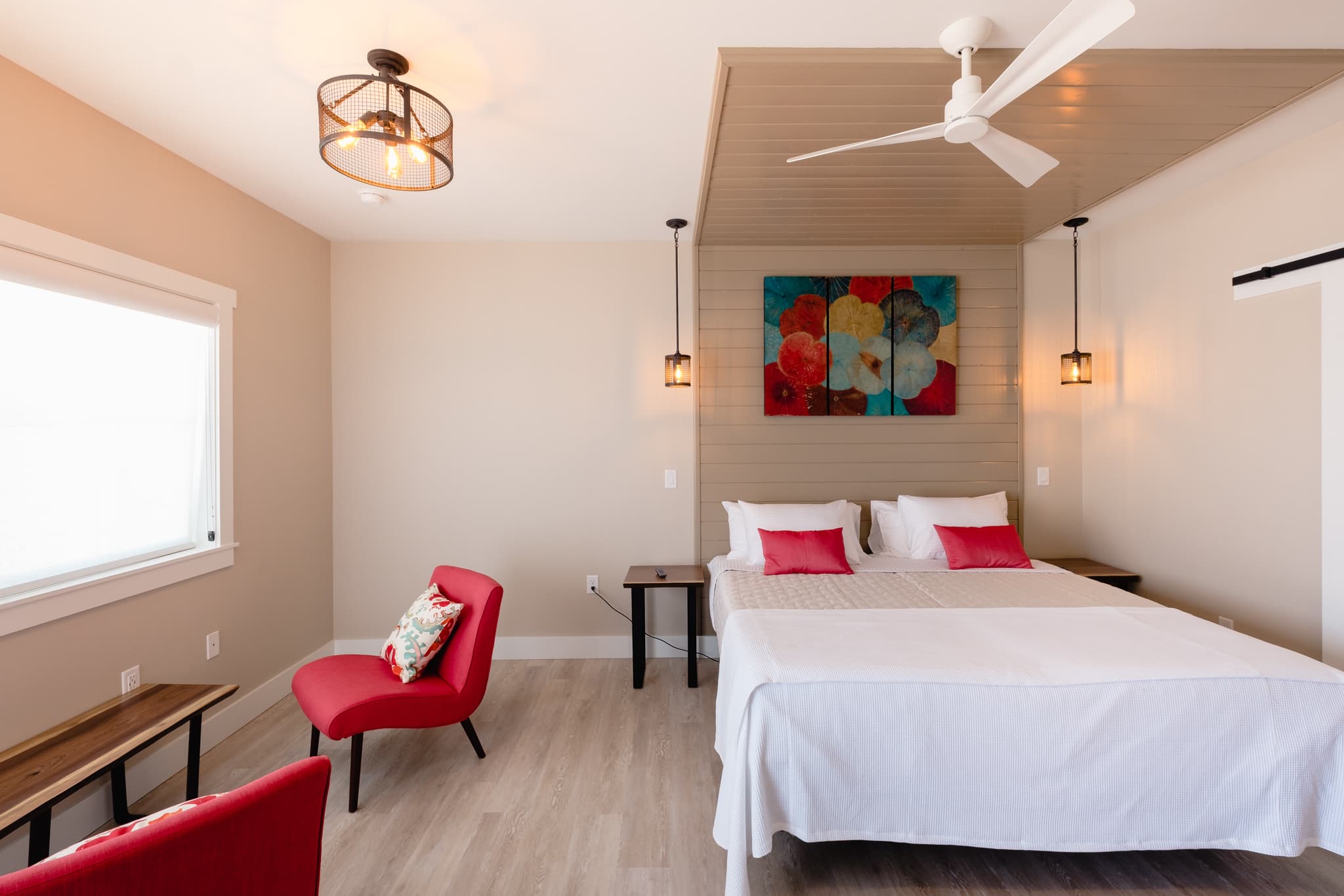 Interior view of the Vendange Suite showing beds, sitting area, entrance to bathroom. Warm colors