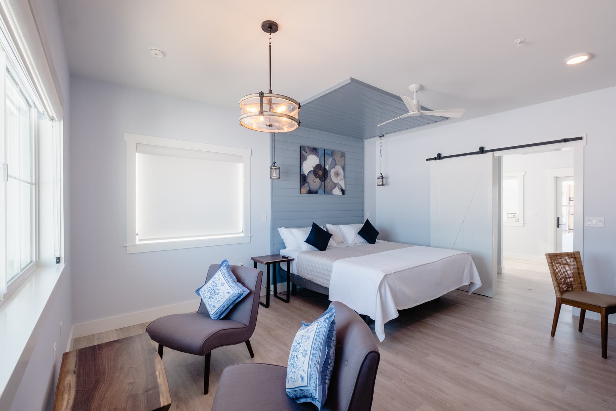 Interior view of the Vinifera Suite showing beds, sitting area, entrance to bathroom. Done in shades of blue.